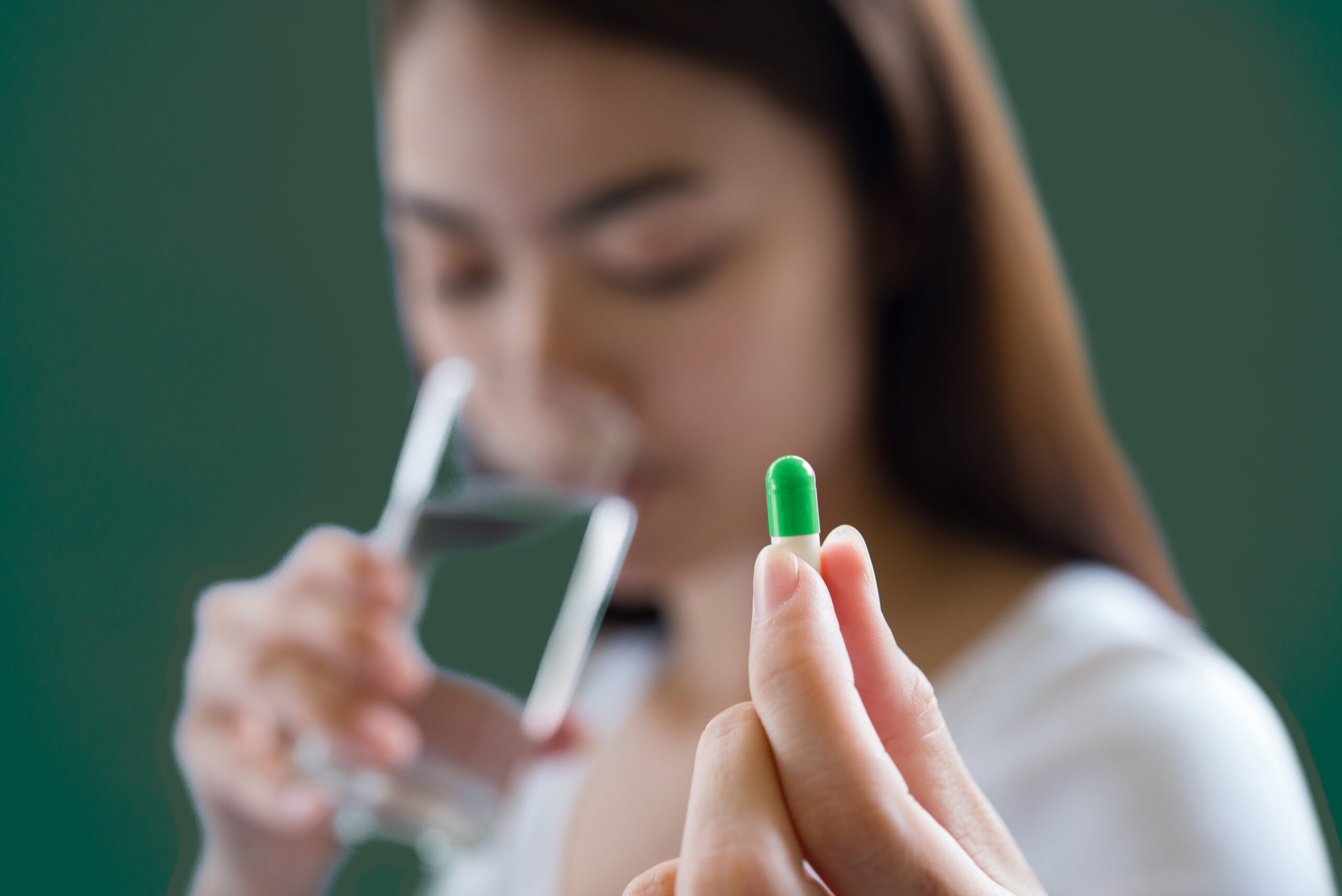 An image of a woman about to take her medicine